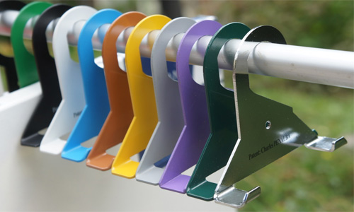cintratableaux multicolores sur barre de portant en extérieur